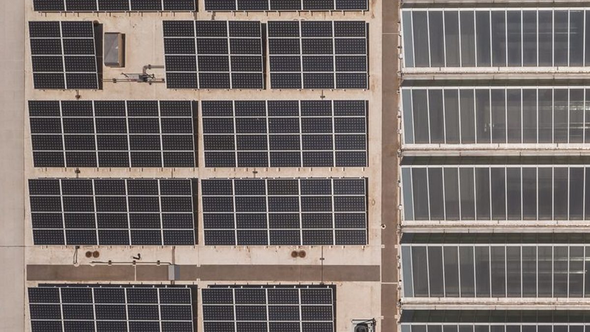 Drone photo of a rooftop with solar panel arrays and skylights